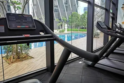 a gym with a treadmill and a swimming pool at HappyHome @ Arte Mont Kiara Kuala Lumpur Hartamas Damansara in Kuala Lumpur
