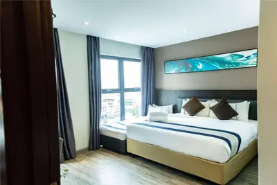a bedroom with a large bed with a large window at Ramada Encore by Wyndham Chinatown Kuala Lumpur in Kuala Lumpur