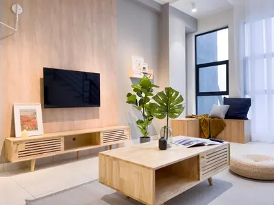 a living room with a tv on a wall at Arte Mont Kiara by CozyNest in Kuala Lumpur