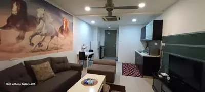 a living room with a couch and a flat screen tv at One Maxim Residence at Taragon in Kuala Lumpur