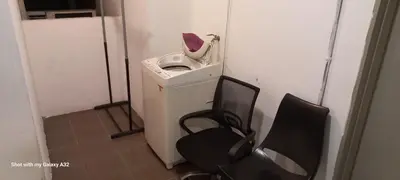 a washing machine in a room with two chairs at One Maxim Residence at Taragon in Kuala Lumpur