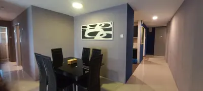 a dining room with a black table and chairs at One Maxim Residence at Taragon in Kuala Lumpur