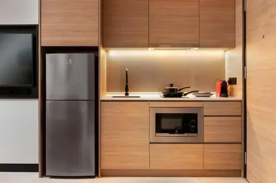 a kitchen with a stainless steel refrigerator and a microwave at Capri by Fraser, Bukit Bintang in Kuala Lumpur