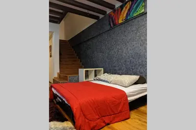 a bedroom with a bed with a red blanket at Cozy designer loft near KL city center in Ampang