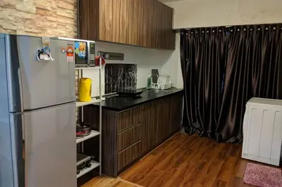 a kitchen with a refrigerator and a wooden floor at Cozy designer loft near KL city center in Ampang