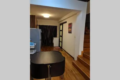 a living room with a black stool and stairs at Cozy designer loft near KL city center in Ampang