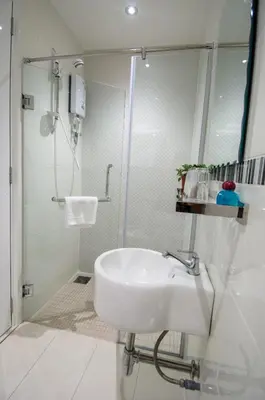 a white bathroom with a shower and a sink at 12FLY Hotel Kuala Lumpur in Kuala Lumpur
