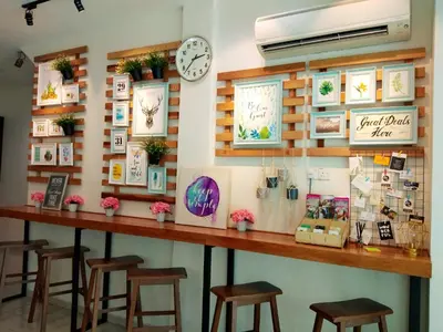 a bar with stools and a clock on a wall at Maple Inn in Kuala Lumpur