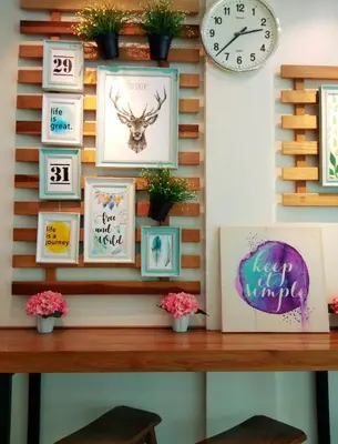 a wooden table with pictures on a wall with a clock at Maple Inn in Kuala Lumpur