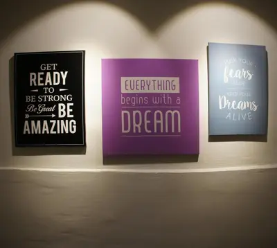 a group of three posters on a shelf at Maple Inn in Kuala Lumpur