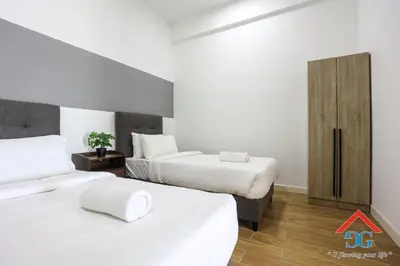two beds in a hotel room with a red triangle at The Elements by Grabstay in Kuala Lumpur