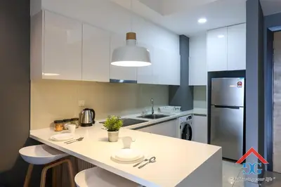 a kitchen with a white counter and a refrigerator at The Elements by Grabstay in Kuala Lumpur