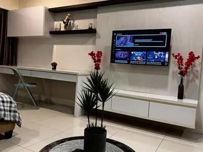 a living room with a tv on the wall at Mercu Summer Suites KLCC by SS Residence in Kuala Lumpur