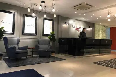 a man standing at a desk in a lobby at Mars Hotel in Kuala Lumpur