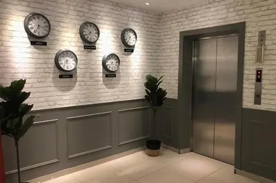 a room with clocks on the wall and a door at Mars Hotel in Kuala Lumpur