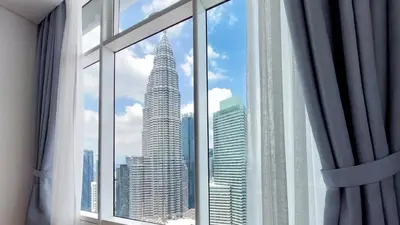 a view of the petronas twin towers from a window at Sky Suites with KLCC Twin Tower View by iRent365 in Kuala Lumpur