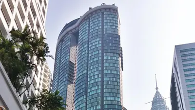 a tall glass building in a city at Sky Suites with KLCC Twin Tower View by iRent365 in Kuala Lumpur