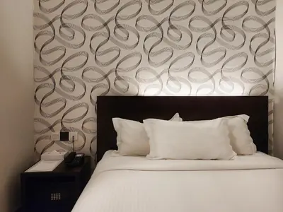 a bedroom with a bed and a wall with swirl patterns at Izumi Hotel Bukit Bintang Kuala Lumpur in Kuala Lumpur