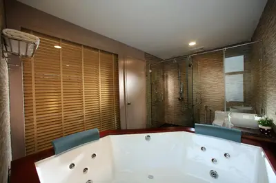 a bathroom with a large tub and two blue chairs at Izumi Hotel Bukit Bintang Kuala Lumpur in Kuala Lumpur