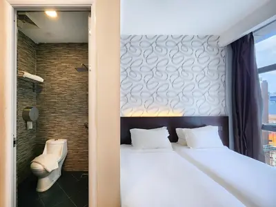 a bedroom with a white bed and a window at Izumi Hotel Bukit Bintang Kuala Lumpur in Kuala Lumpur