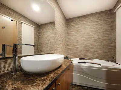 a bathroom with a large white sink and a tub at Izumi Hotel Bukit Bintang Kuala Lumpur in Kuala Lumpur