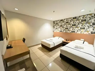 a hotel room with two beds and a flat screen tv at Seeds Hotel Premier Pudu Kuala Lumpur Previously Hotel Pudu Plaza KL in Kuala Lumpur