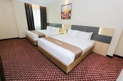 a hotel room with two beds in it at Metro Hotel Bukit Bintang in Kuala Lumpur