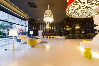 a living room with yellow chairs and a chandelier at Arte Mont Kiara Homestay in Kuala Lumpur