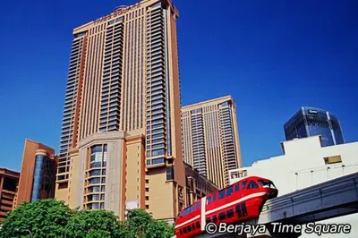a red train in front of some tall buildings at Fantazya Suites Times Square in Kuala Lumpur