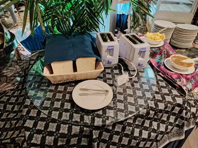 a glass table with plates and utensils on it at Alamis City Kuala Lumpur - Formerly EDC Hotel Kuala Lumpur in Kuala Lumpur