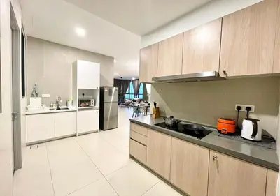 a large kitchen with wooden cabinets and appliances at KL Gateway Premium Residences by Moka in Kuala Lumpur
