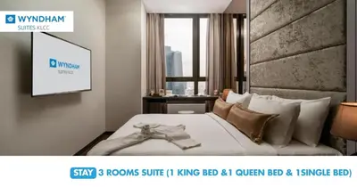 a bedroom with a bed with a tv on the wall at Wyndham Suites KLCC in Kuala Lumpur