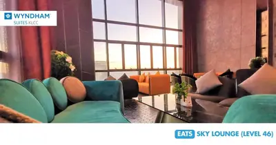 a living room with couches and a large window at Wyndham Suites KLCC in Kuala Lumpur