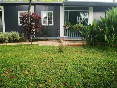 a gray house with a front yard with a yard at Titiwangsa Cabin Retreats by Vale Pine in Kuala Lumpur