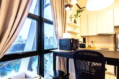 a kitchen with a counter with a microwave and a window at Arte Mont Kiara by Airhost in Kuala Lumpur