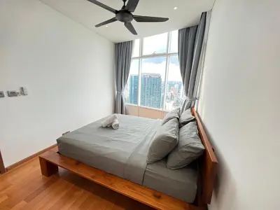 a bed in a room with a large window at Sky Suites KLCC by GENESIS in Kuala Lumpur
