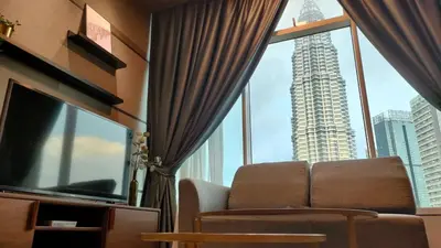 a living room with a couch and a large window at KLCC Homestay Vacation Sky Suites KLCC Birdy Stay in Kuala Lumpur