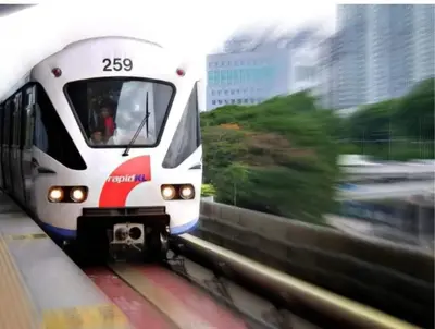 a train traveling down the tracks in a city at KLCC Homestay Vacation Sky Suites KLCC Birdy Stay in Kuala Lumpur