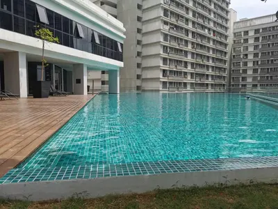 an empty swimming pool in a building with tall buildings at KL Gateway Premium Residence I HomeBrickz in Kuala Lumpur