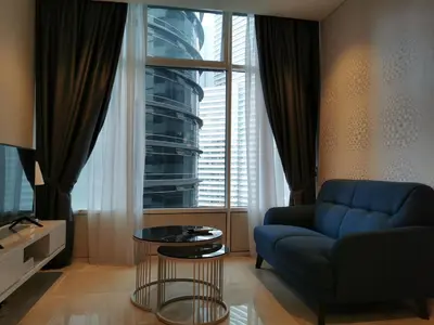 a living room with a blue couch and a large window at Sky Suites KLCC by Autumn Suites Premium Stay in Kuala Lumpur