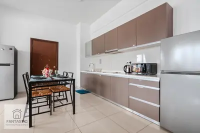 a kitchen with a table and a refrigerator at Regalia Residence @ KLCC View Sky Pool by KC in Kuala Lumpur