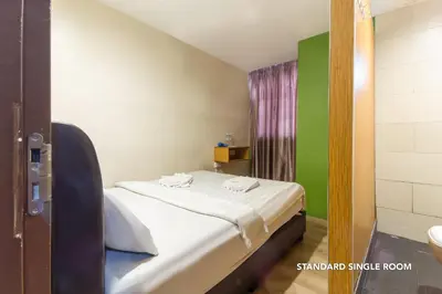 a small room with a bed and a green wall at 33 Star Hotel by The Awinka Group Of Management in Kuala Lumpur