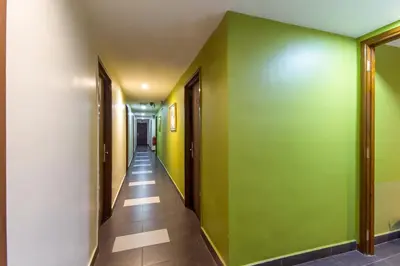 a hallway with green and white walls and wooden floors at 33 Star Hotel by The Awinka Group Of Management in Kuala Lumpur