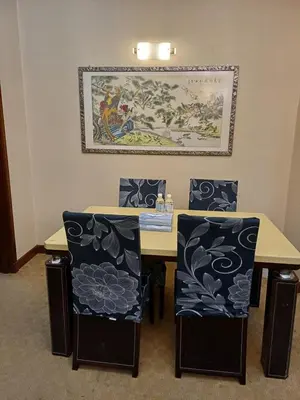 a dining room table with two chairs and a painting on the wall at Times Square Grand Service Suite in Kuala Lumpur