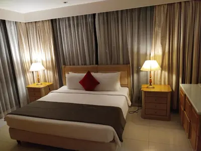 a bedroom with a large bed and two lamps on tables at Times Square Grand Service Suite in Kuala Lumpur