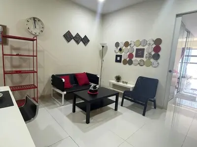 a living room with a table and chairs and a clock at Stylish Romantic Couples Getaway at KL City 1419 in Kuala Lumpur