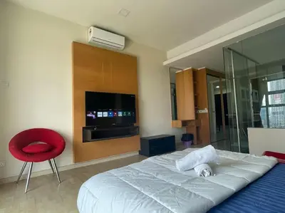 a bedroom with a bed and a red chair at Stylish Romantic Couples Getaway at KL City 1419 in Kuala Lumpur