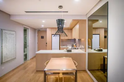 a kitchen with a table and a dining room at 188 Suites KLCC by CoBNB in Kuala Lumpur