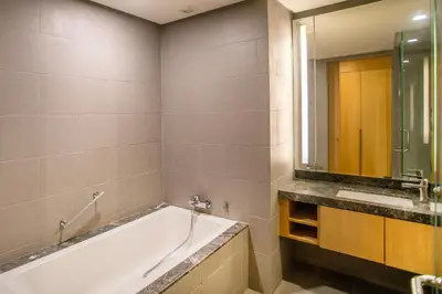 a bathroom with a tub and a sink and a mirror at 188 Suites KLCC by CoBNB in Kuala Lumpur