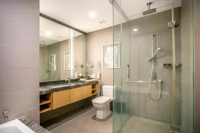 a bathroom with a toilet and a glass shower at 188 Suites KLCC by CoBNB in Kuala Lumpur
